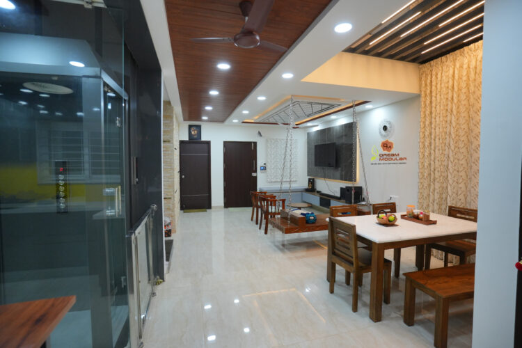 Modern dining and living room interior with glossy tiled floors, furnished with a dining table, chairs, and a seating area, with ambient lighting.