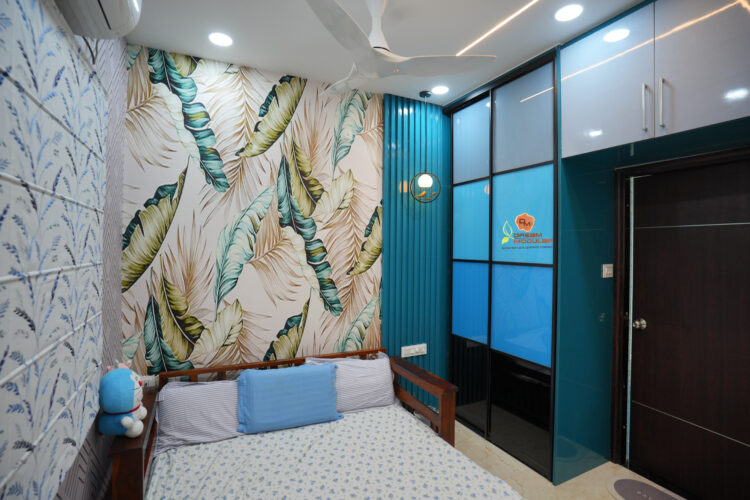 A modern room with a tropical leaf-patterned accent wallpaper, blue Sliding Wardrobes, and matching bed Rafters.