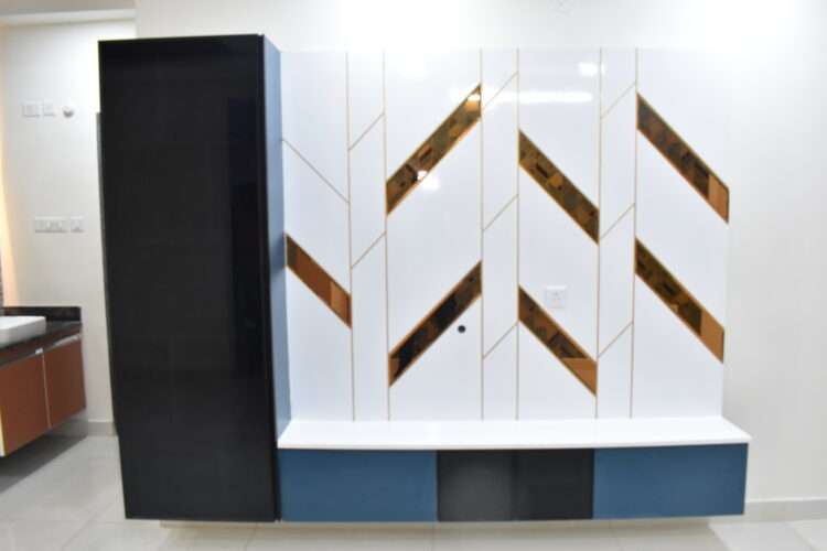 a white and blue wall with gold designs TV Unit Interior Design - Dream Modular